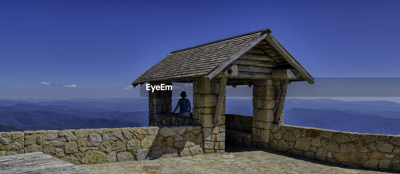 Rear view of woman looking at mountains while standing at observation point