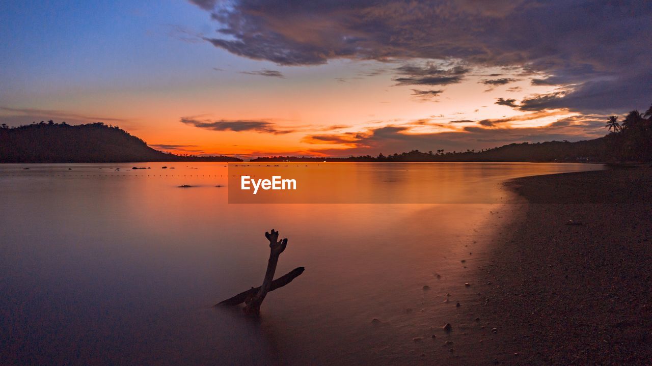 SCENIC VIEW OF SEA AGAINST ORANGE SKY