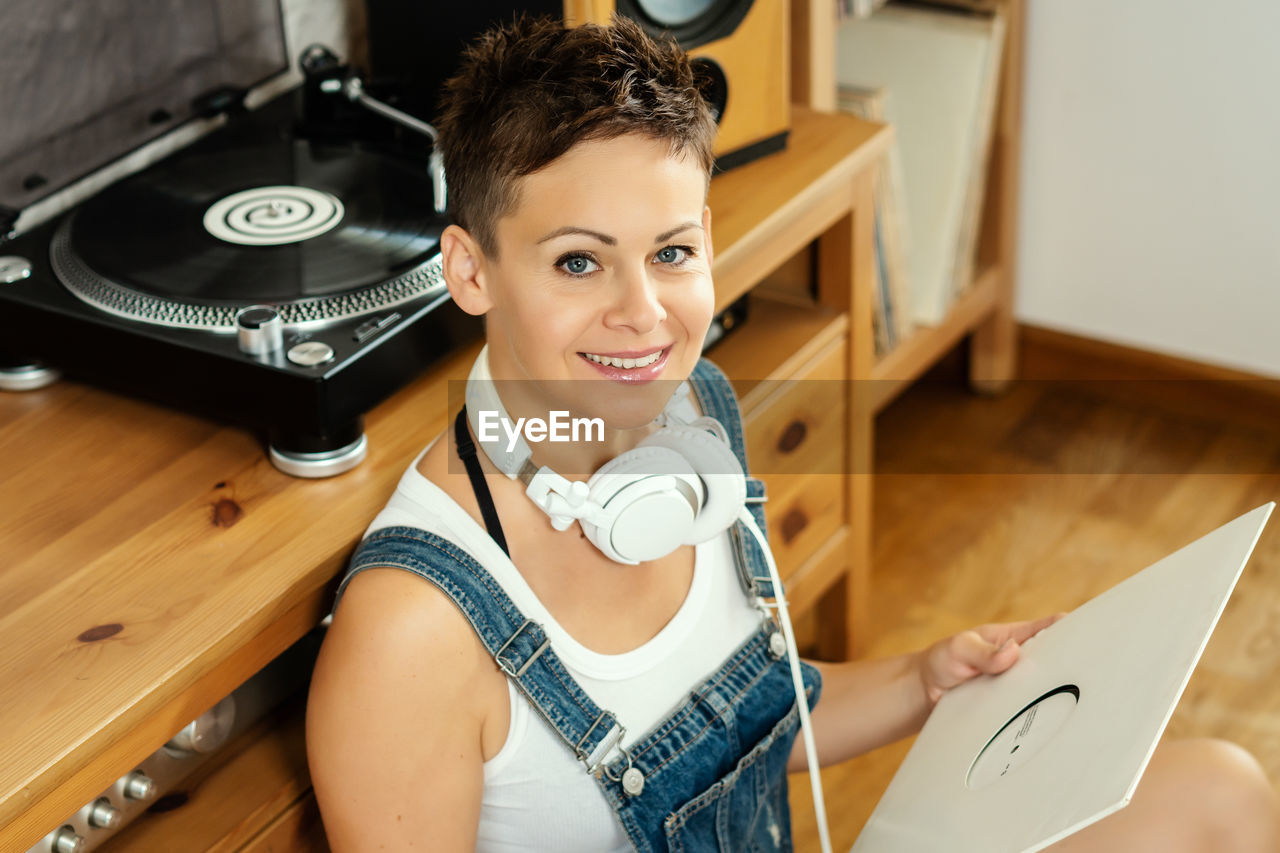 Portrait of woman holding record at home