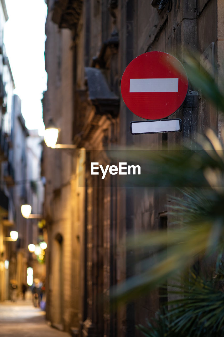 ROAD SIGN ON STREET BY BUILDINGS IN CITY