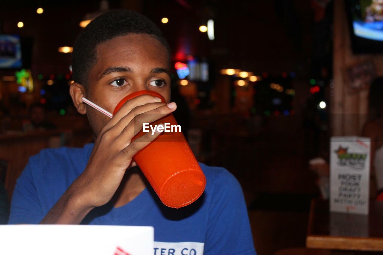 Portrait of young man drinking juice