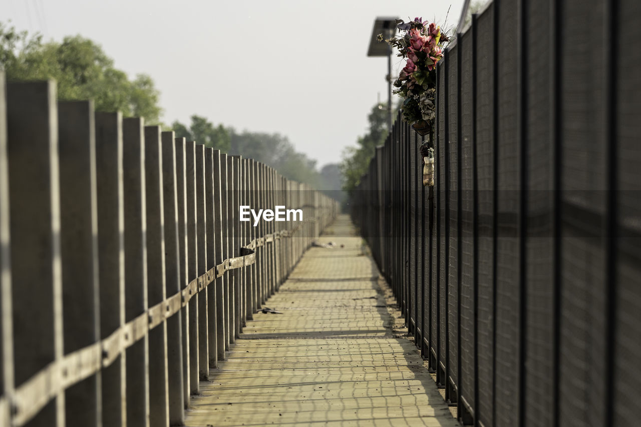 Footpath amidst fence