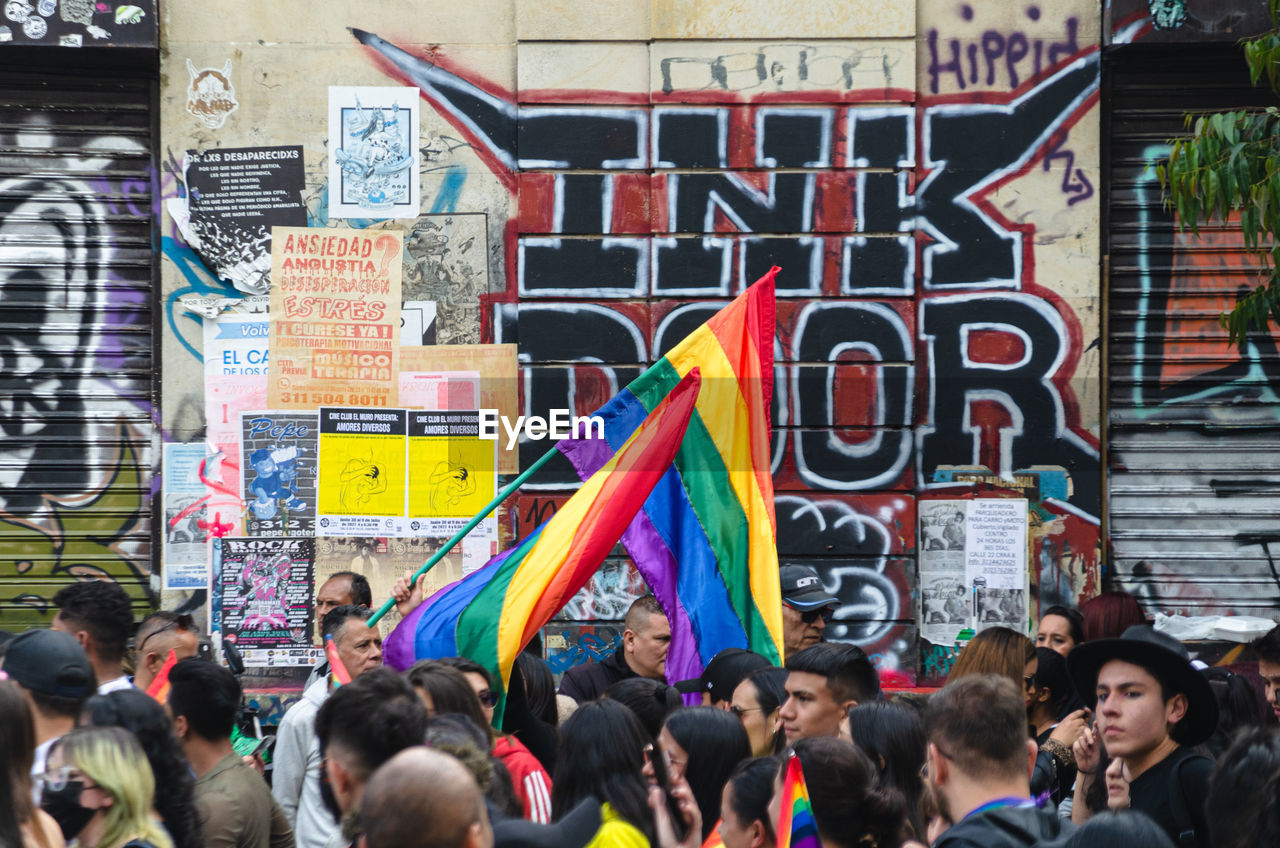 crowd, group of people, architecture, large group of people, city, multi colored, street, protest, men, women, event, building exterior, adult, built structure, flag, lifestyles, social issues, city life, communication, human face, clothing, rainbow, outdoors, text, day, person, education