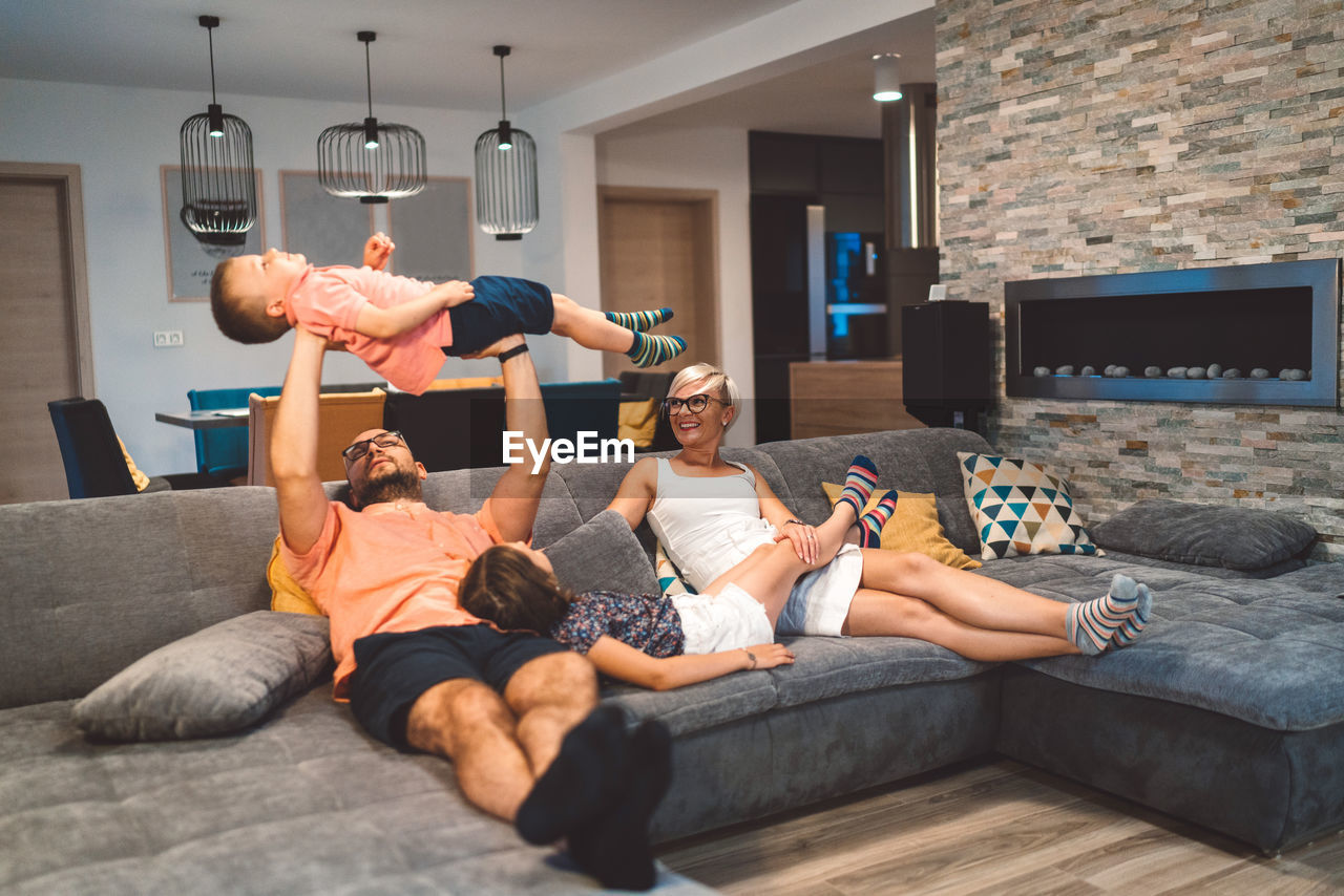 side view of woman exercising on sofa at home