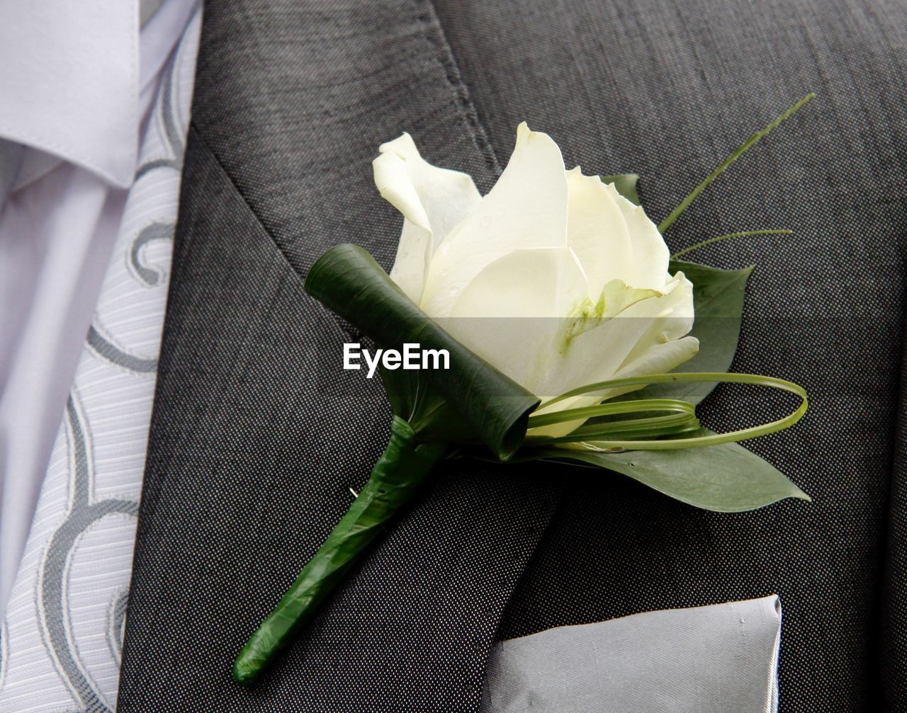 Close up of cream rose button hole for groom in wedding day
