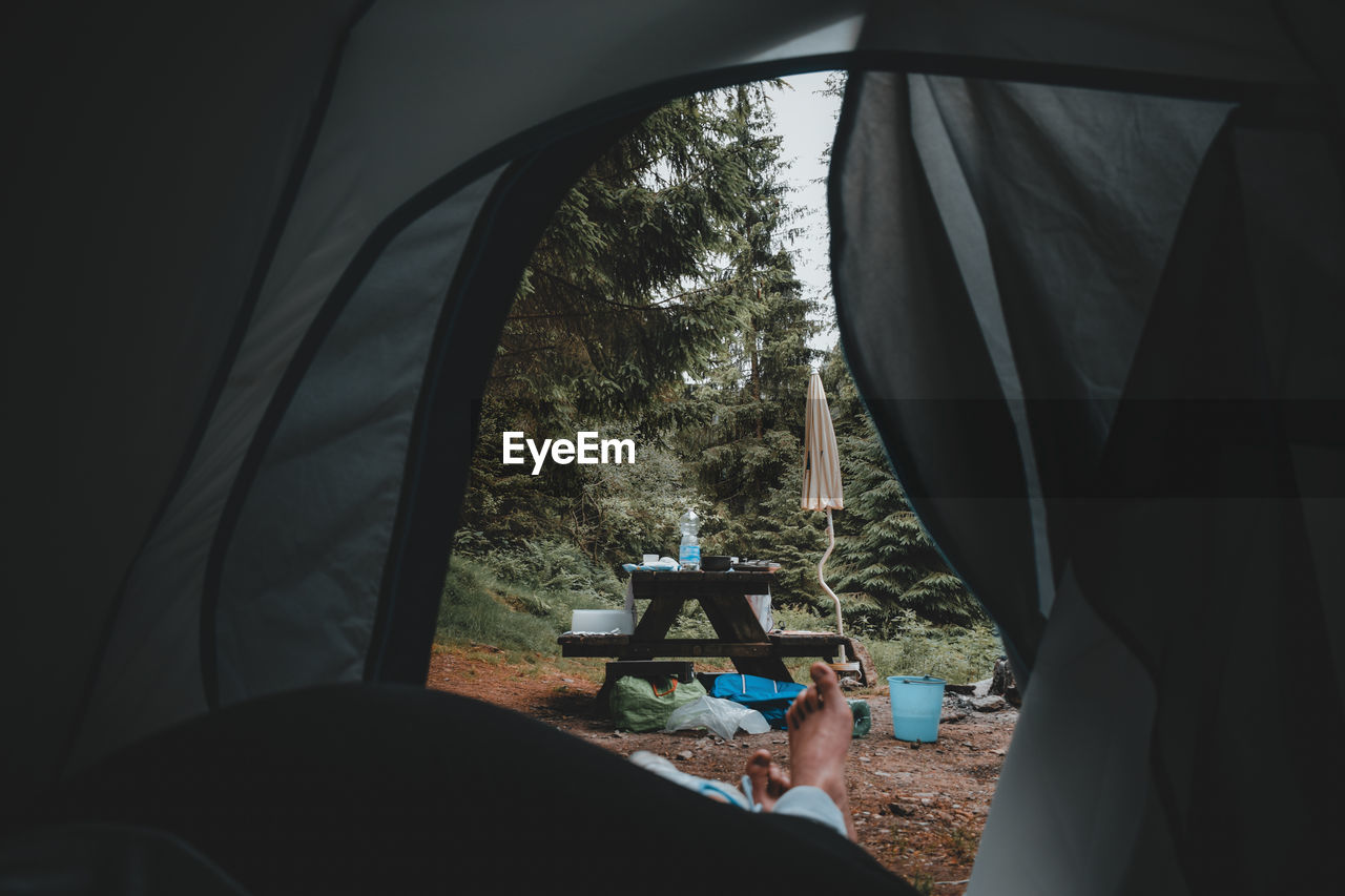 PEOPLE SITTING IN TENT SEEN THROUGH WINDOW OF CAR