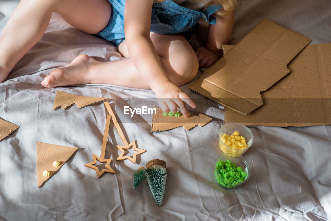 HIGH ANGLE VIEW OF WOMAN SITTING IN BOX ON TABLE