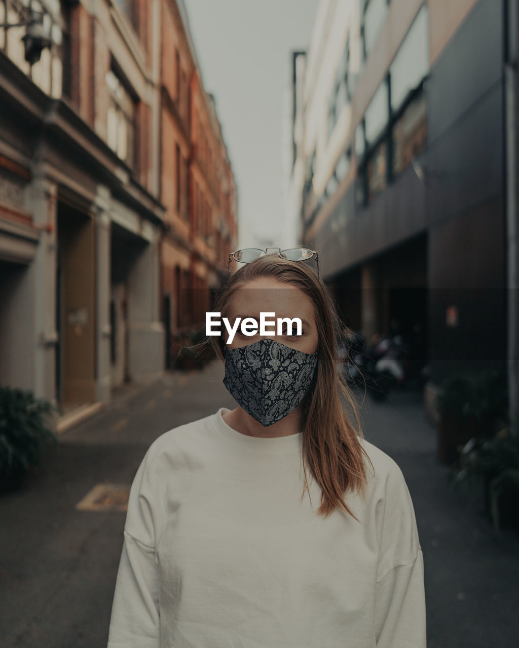 Portrait of young woman wearing mask standing outdoors