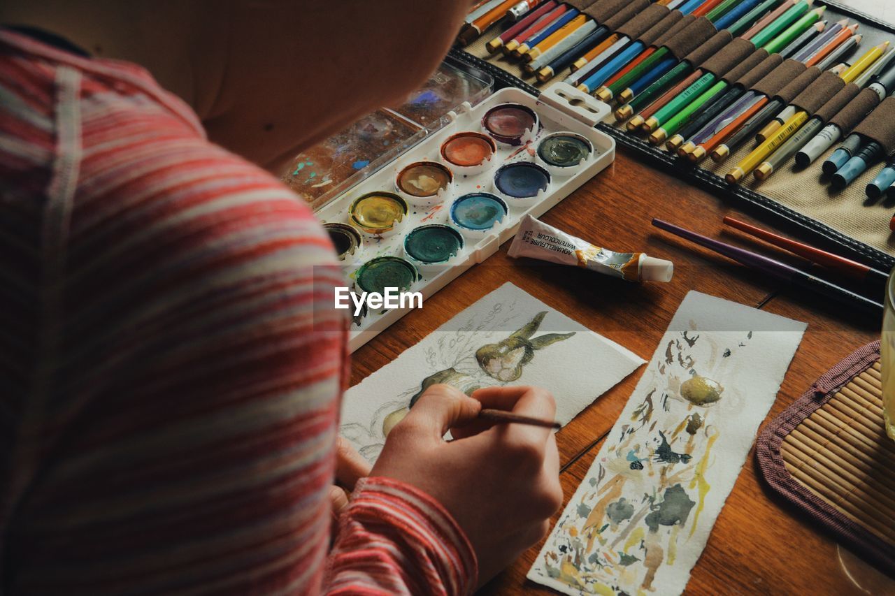 Cropped image of woman painting easter bunny