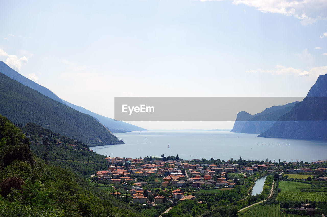 Scenic view of town by sea against sky