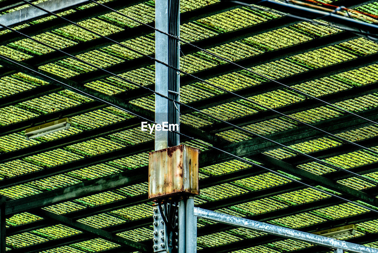 Low angle view of fuse box on pole below green roof