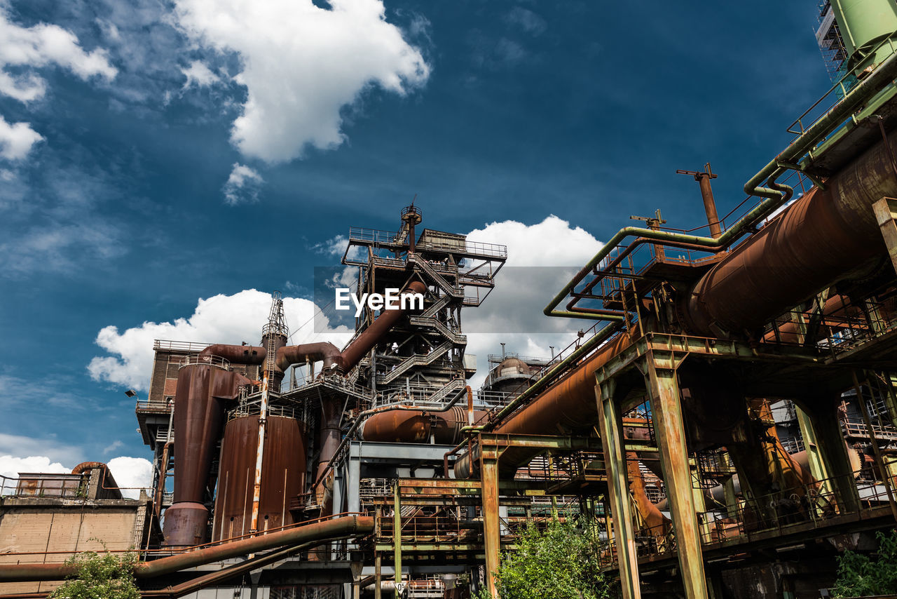 Low angle view of industry against sky
