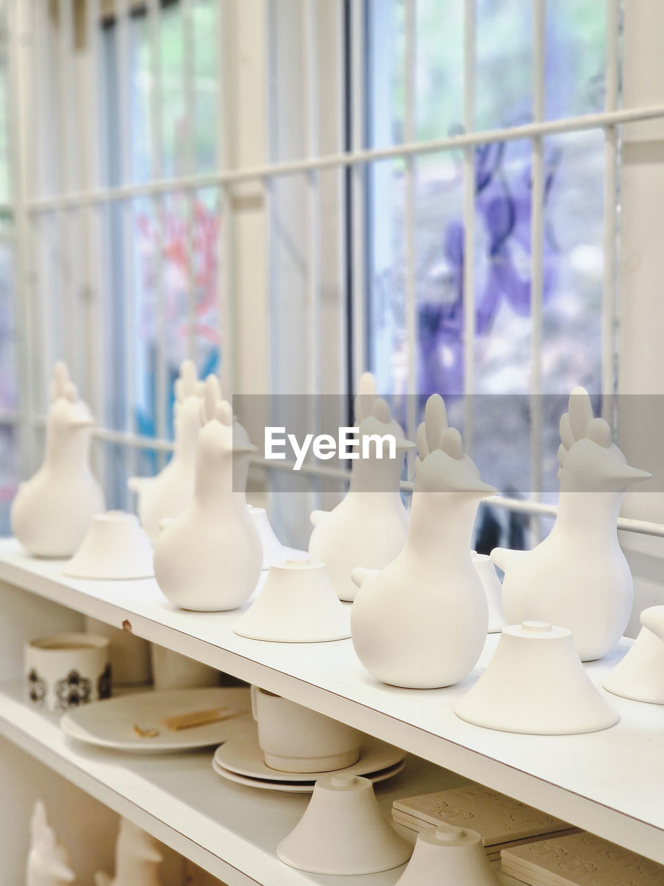 window, retail, indoors, ceramic, store, no people, business, white, pottery, shopping, fashion, porcelain, large group of objects, vase, craft, glass, day, retail display, shelf, elegance, focus on foreground