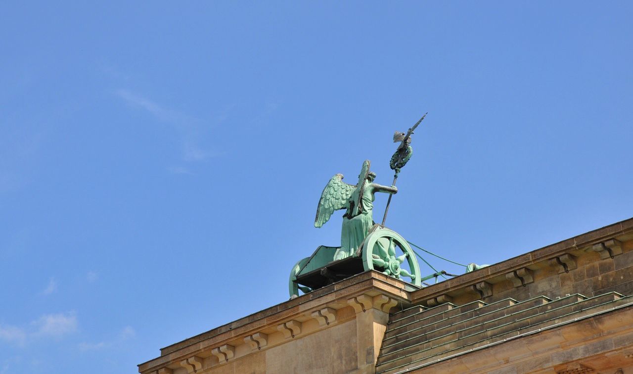 Low angle view of statue against blue sky