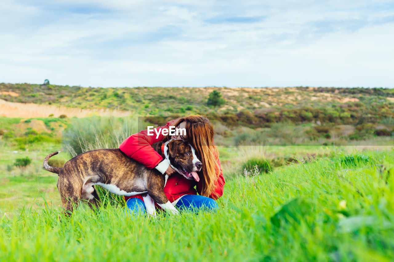 Woman and dog on field