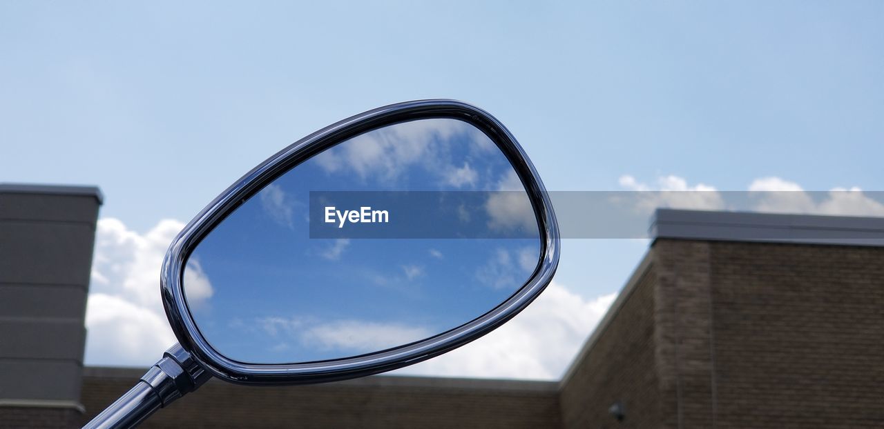 Low angle view of glass building against sky