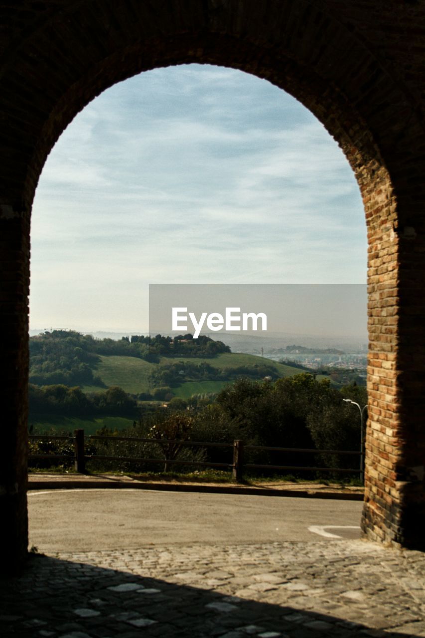 TREES SEEN THROUGH ARCHWAY OF WINDOW