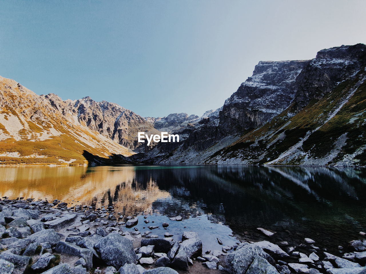 Scenic view of lake and mountains against clear sky