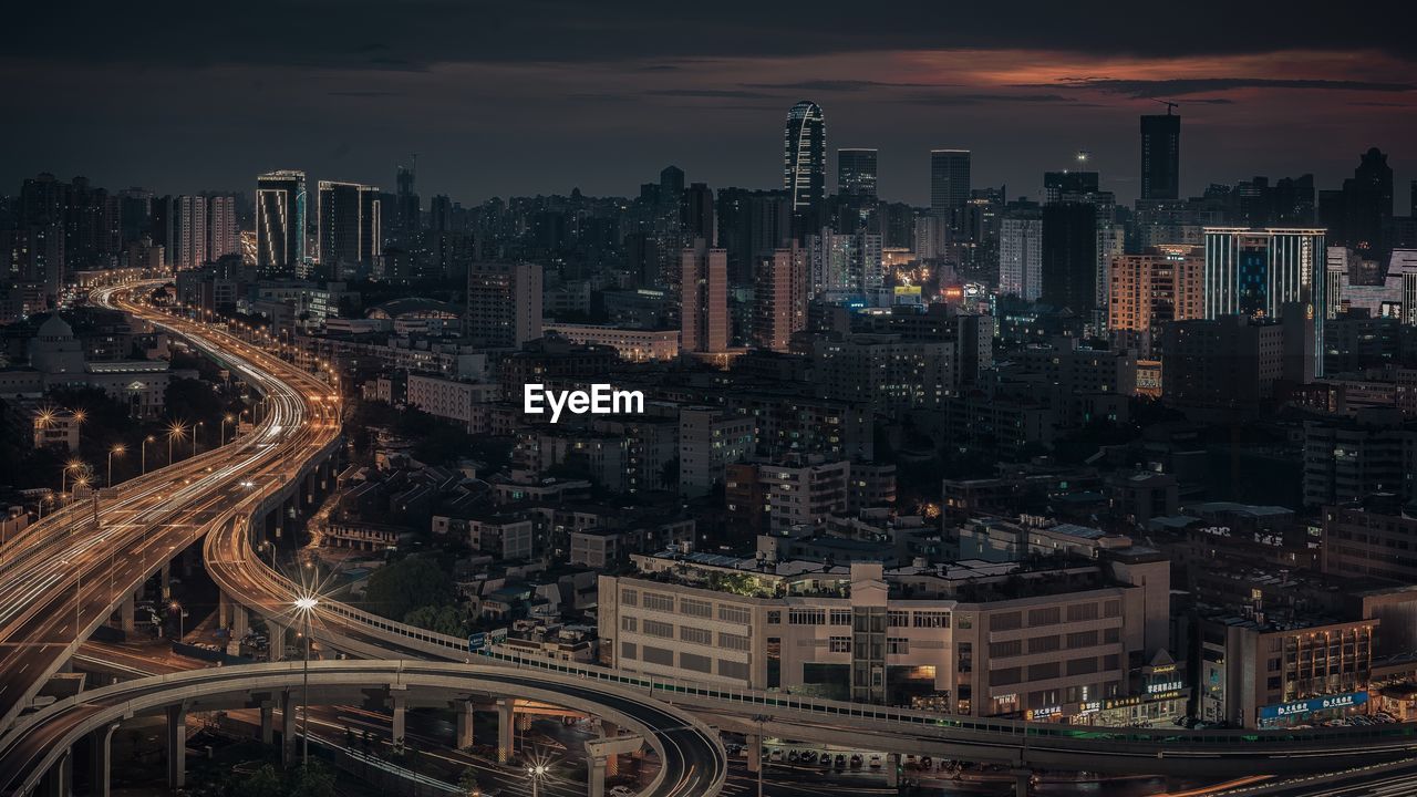 High angle view of illuminated city buildings against sky