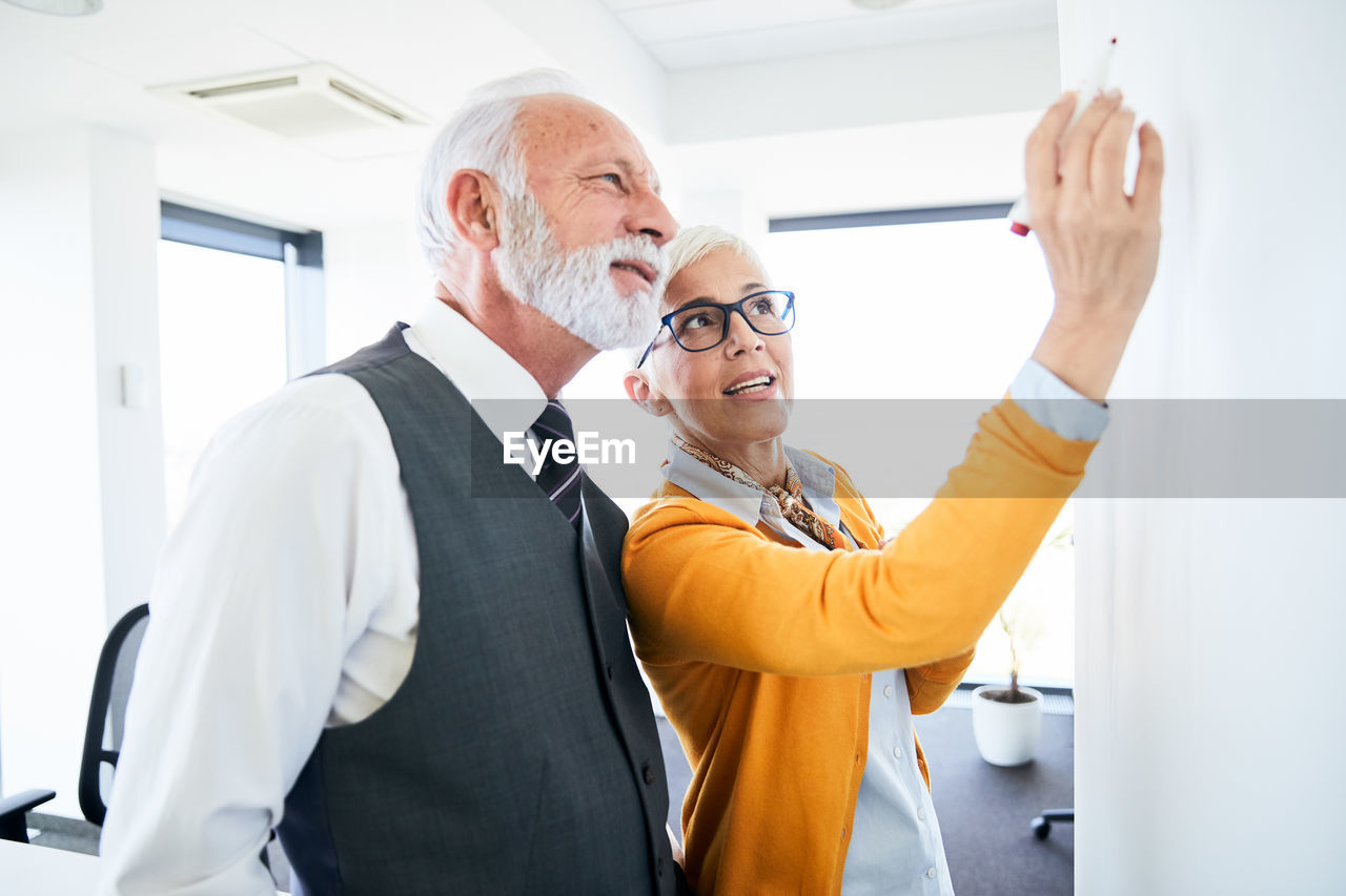 Woman giving presentation to man in office