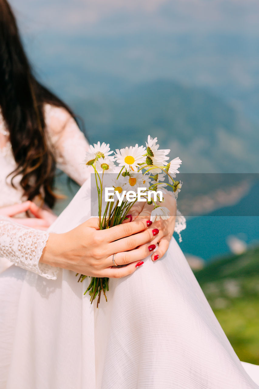 Midsection of woman holding flower bouquet