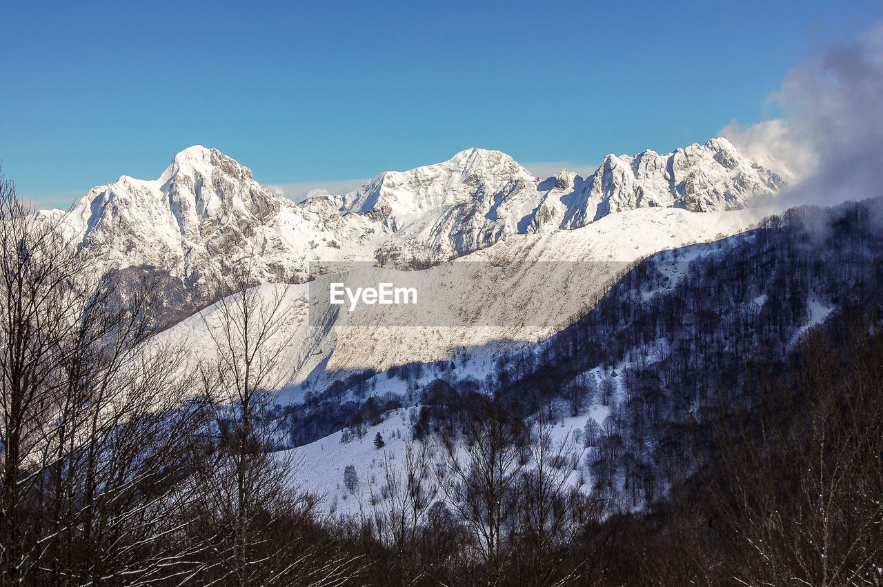 Scenic view of snowcapped mountains against clear blue sky