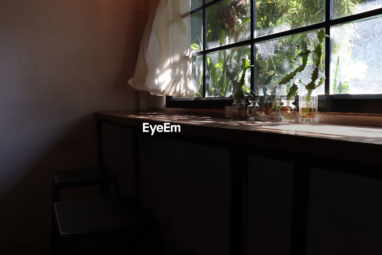 Some glass of drinking water in front of the clear glass window with white fabric curtain