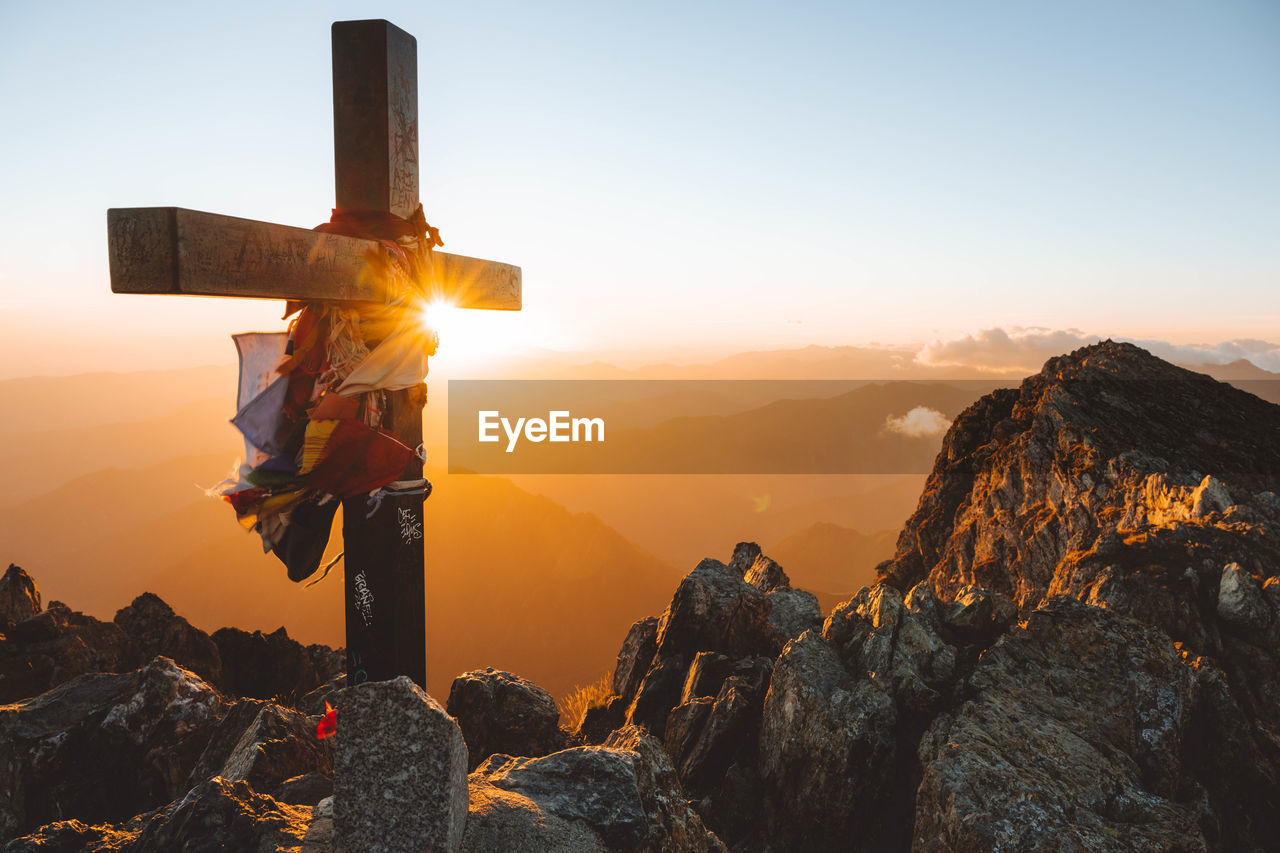 A cross at the summit of mont valier, pyrenees at sunrise.