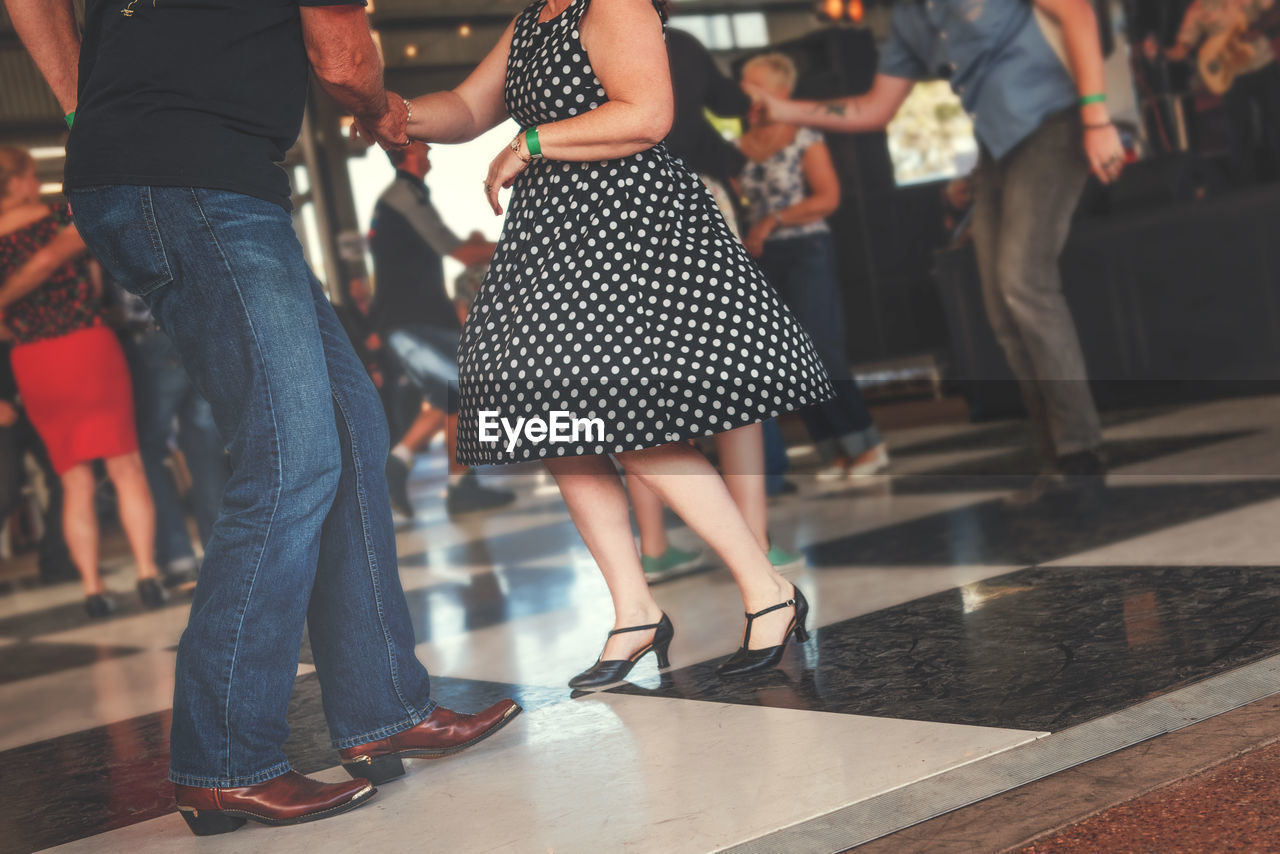 Low section of friends dancing on floor at party