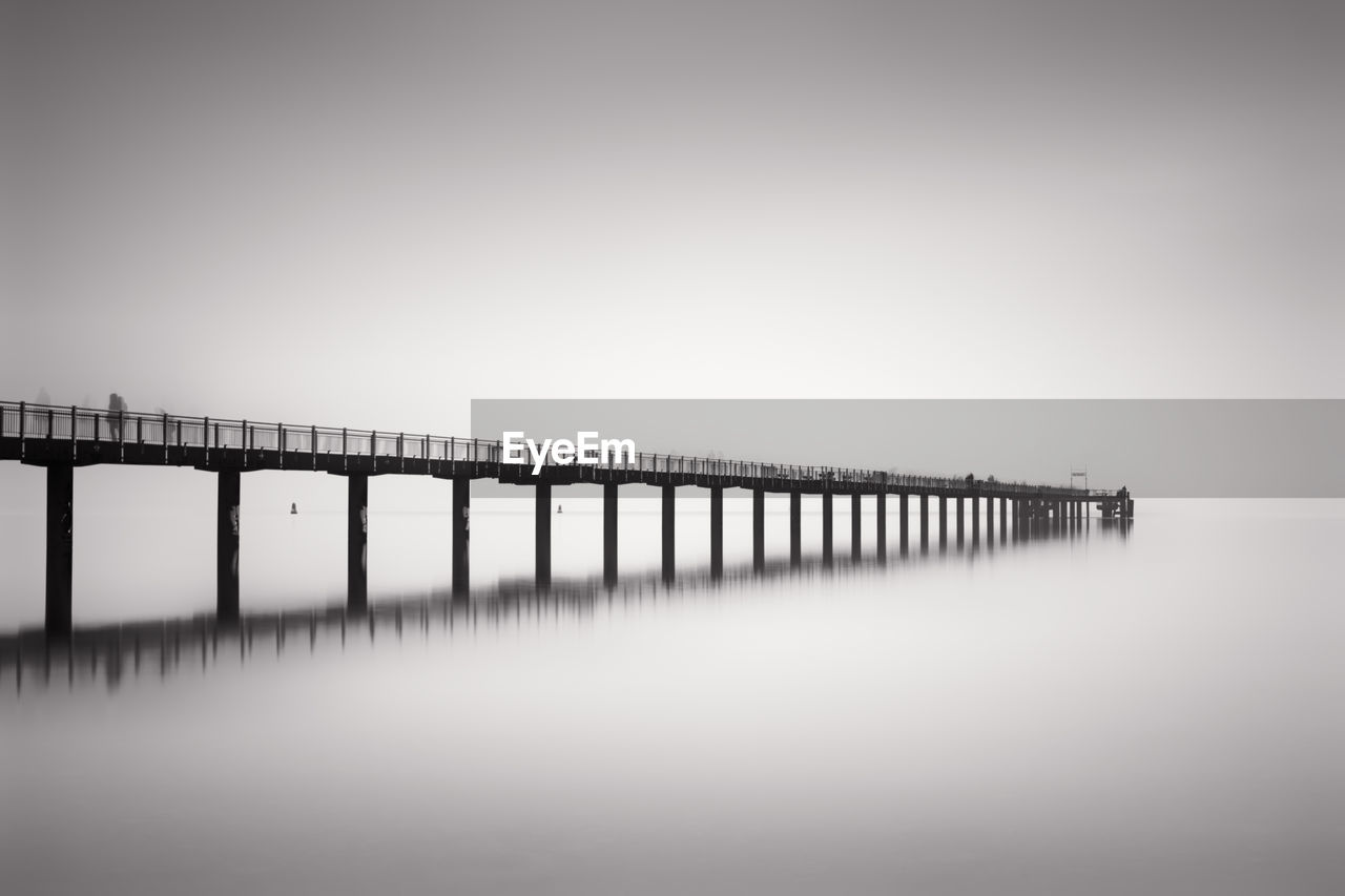 Pier over sea against clear sky