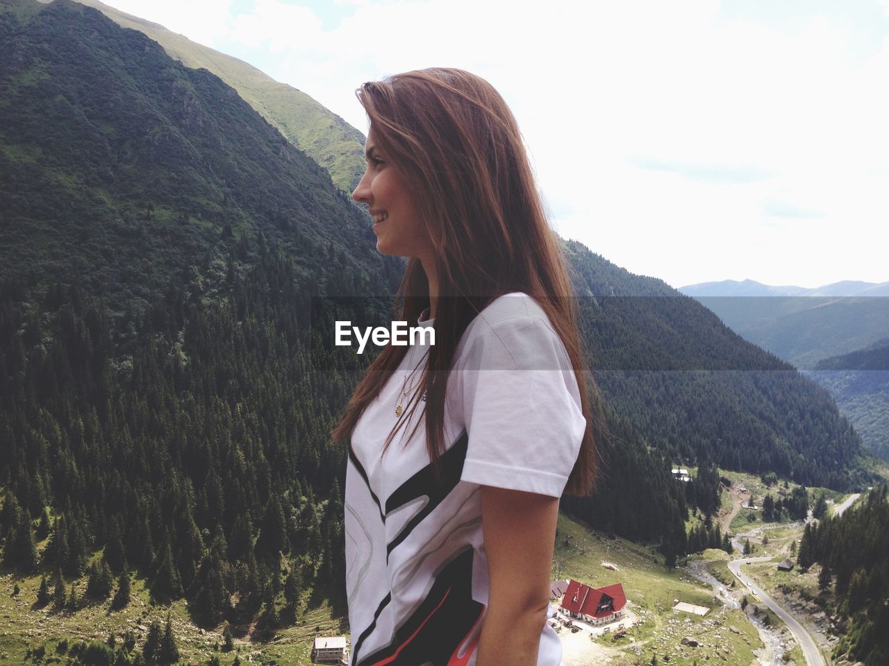 Side view of young woman standing on mountain