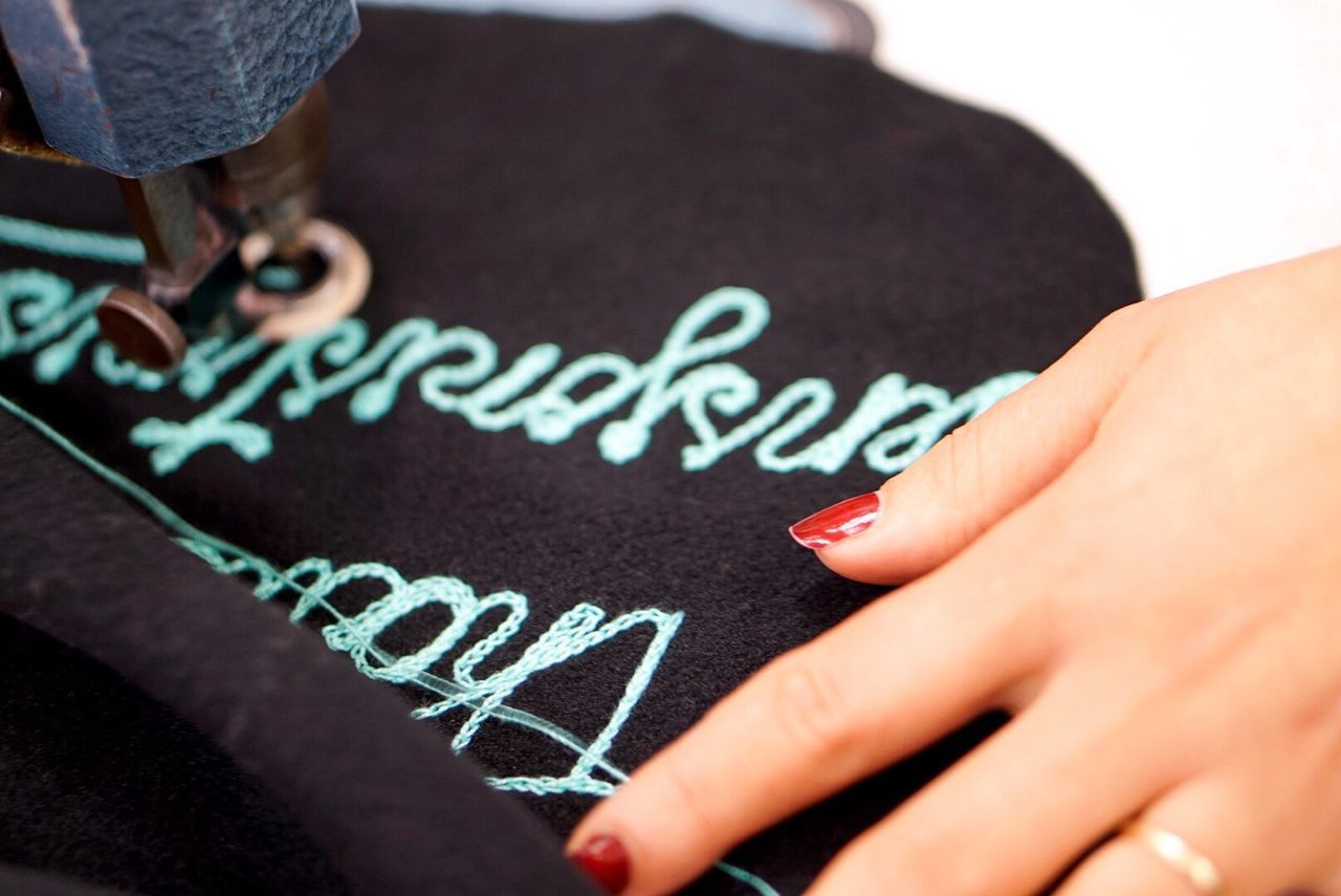 CLOSE-UP OF WOMAN HAND WITH TEXT ON WALL