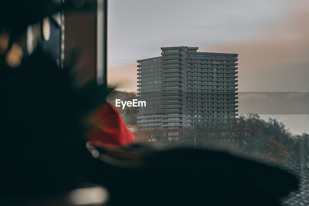 Close-up of buildings against sky seen through glass window