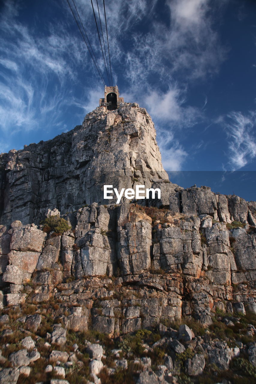 Low angle view of cliff against sky