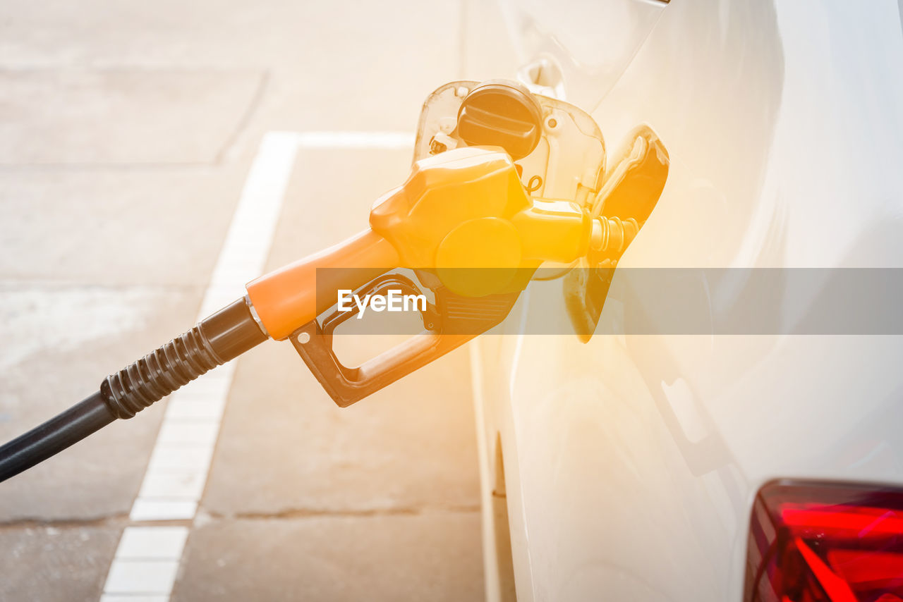 Fuel pump refueling car at gas station