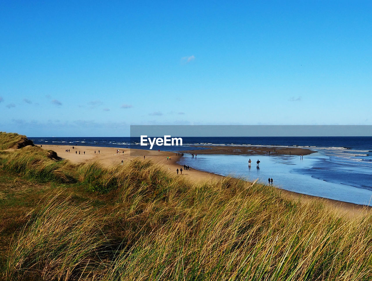 Scenic view of beach against blue sky