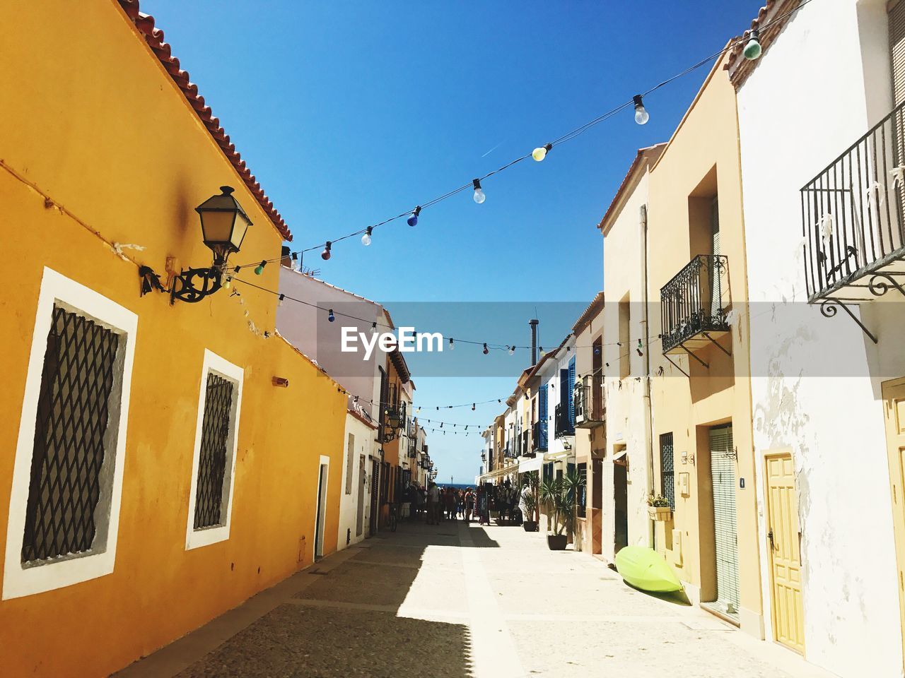 Alley amidst buildings against clear sky