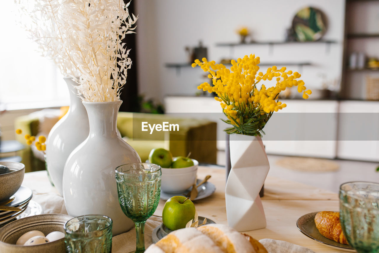 Bright spring mimosa in a ceramic geometric vase in the decor serving a festive or home table 