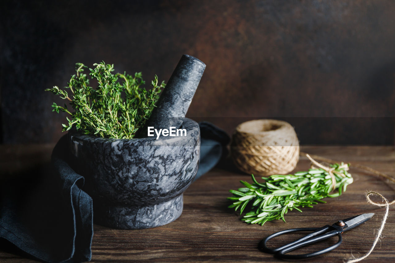 Close-up of mortar and pestle with herbs on table