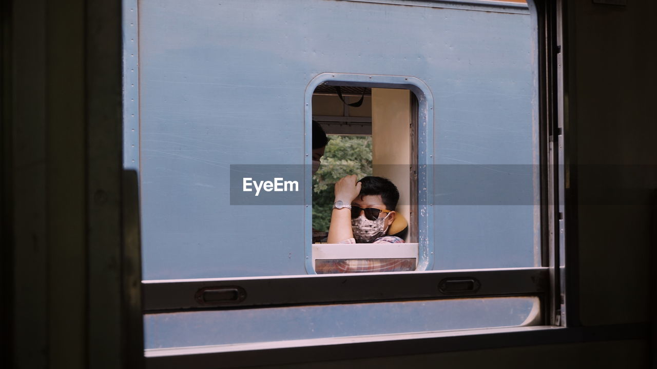 Portrait of man seen through train window