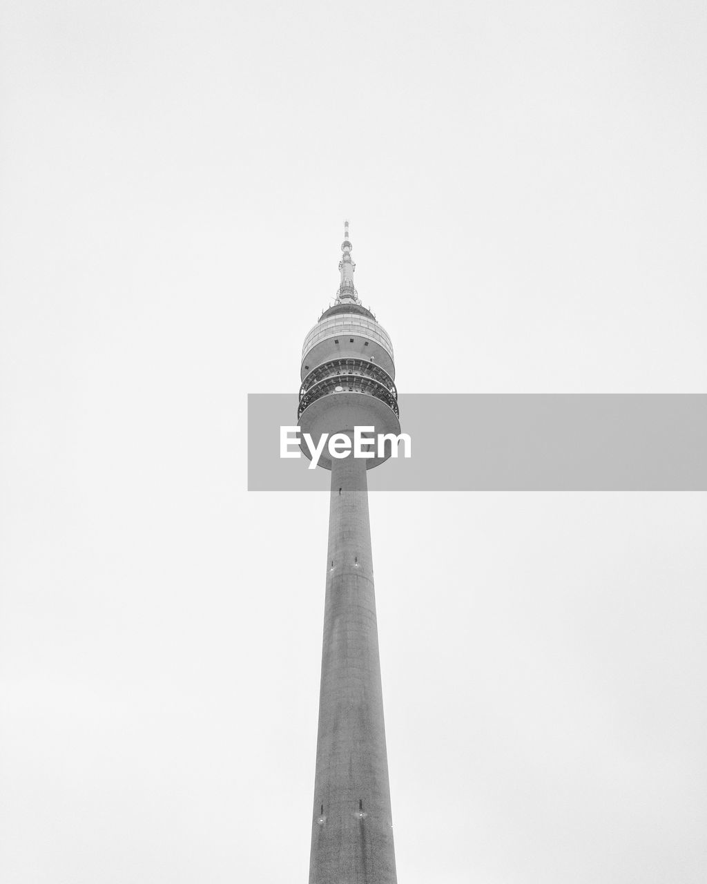 LOW ANGLE VIEW OF COMMUNICATIONS TOWER IN CITY AGAINST CLEAR SKY
