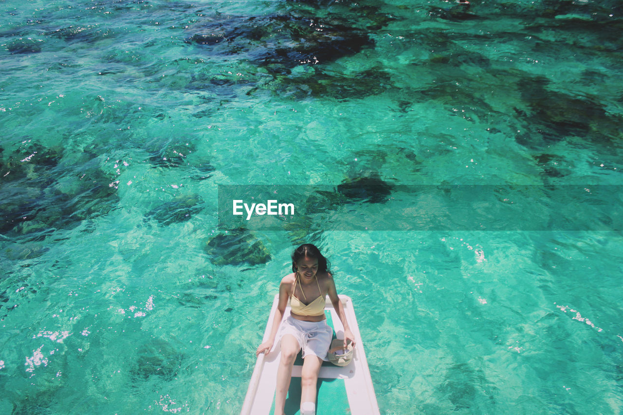 High angle view of woman sitting in boat on sea