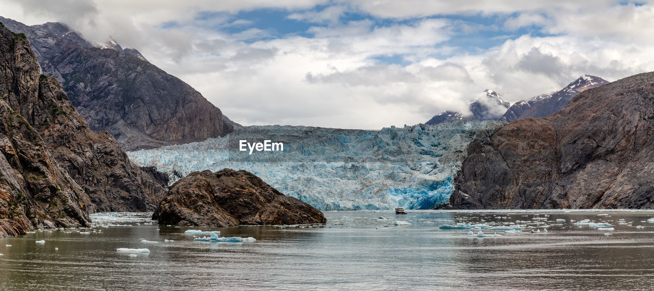 SCENIC VIEW OF SEA AGAINST MOUNTAINS