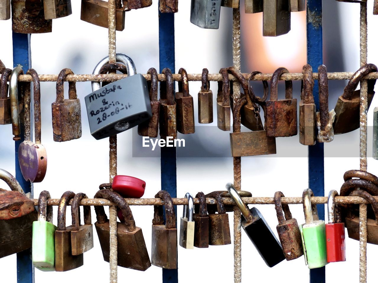 CLOSE-UP OF LOVE PADLOCKS HANGING ON METAL POST