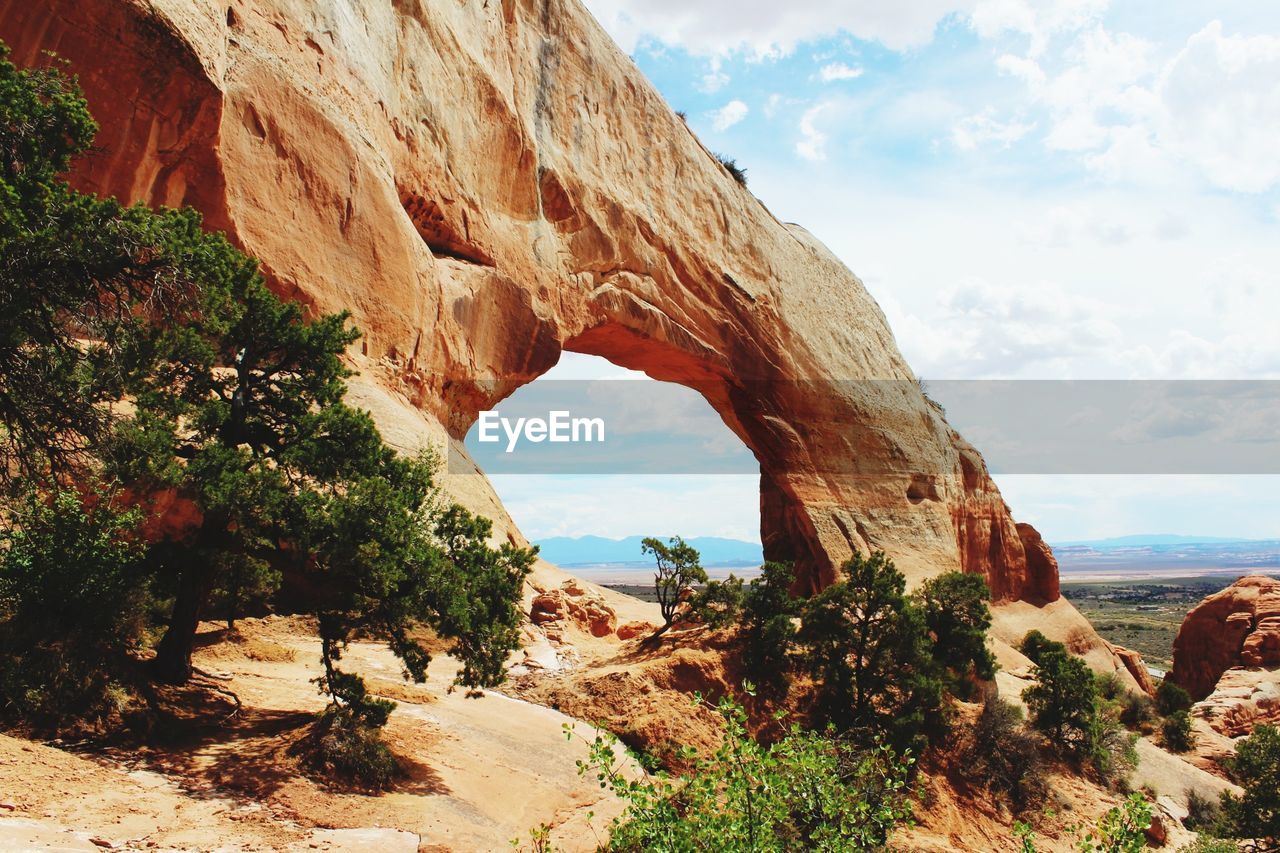 SCENIC VIEW OF ROCK FORMATIONS BY SEA AGAINST SKY