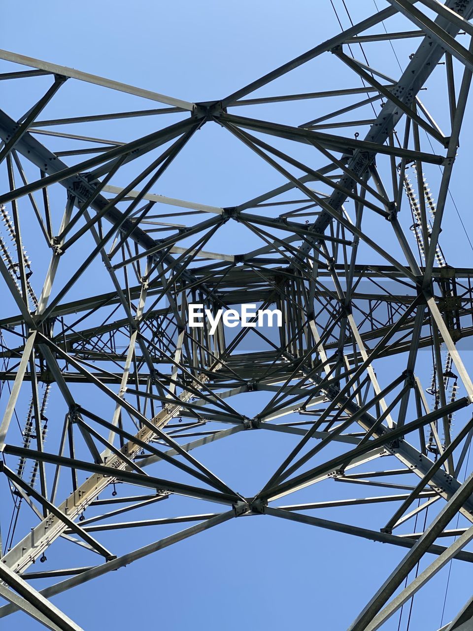 DIRECTLY BELOW SHOT OF ELECTRICITY PYLON AGAINST CLEAR SKY