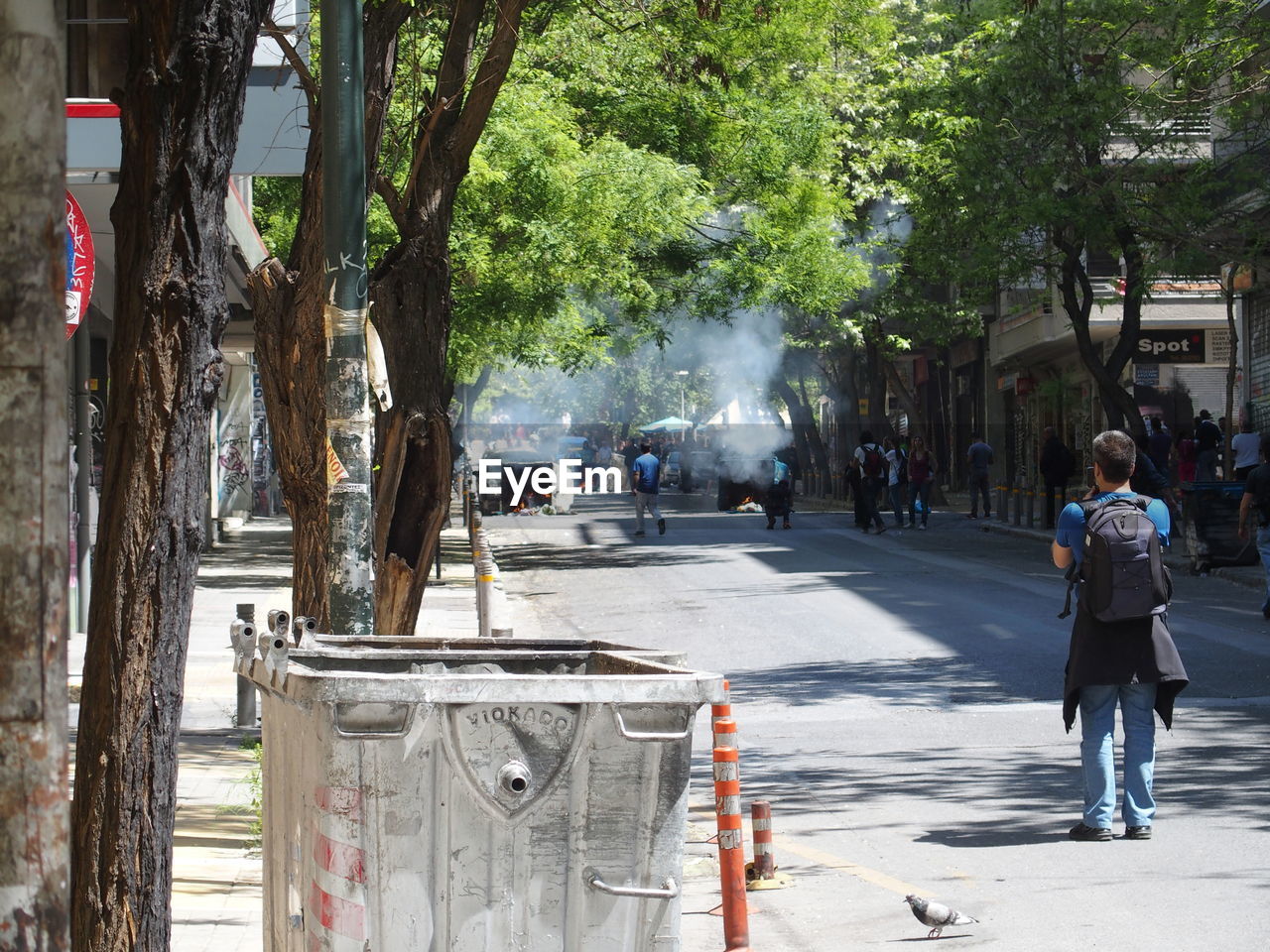 Rear view of man looking at riot on city street