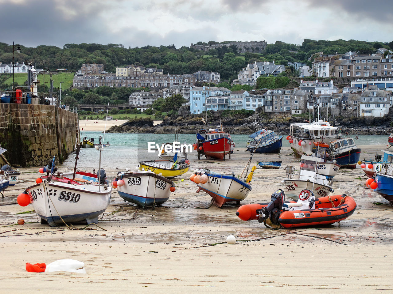 Boats moored at beach against buildings