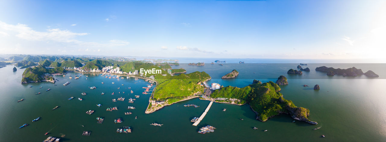 HIGH ANGLE VIEW OF BOATS IN SEA AGAINST BLUE SKY