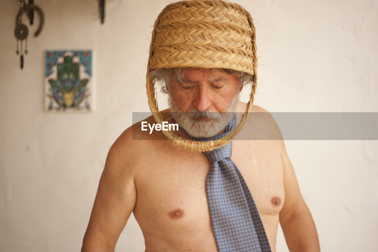 PORTRAIT OF MAN WEARING HAT AGAINST WALL